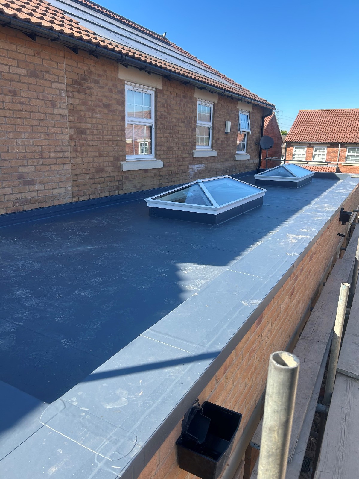 Two white frame roof lanterns installed on a larger flat roof